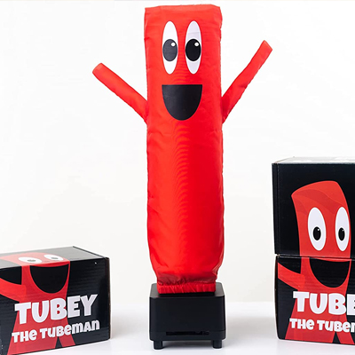 An inflatable tubeman named Tubey is erected by the air blowing inside smiling with its hands up