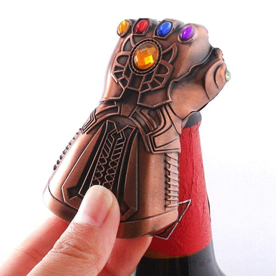 A beer bottle opener in the shape of Infinity Gauntlet from The Avengers movies is opening a beer bottle.
