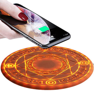 A wireless phone charging pad in the shape of a mystic glowing circle altar of orange color is presented with a phone being placed on it. The charging pad has mystic symbols inscribed on it.