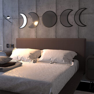 In a cozy room on a bed a set of moon phases mirrors are symmetrically aligned with the full moon at center and it looks beautiful.