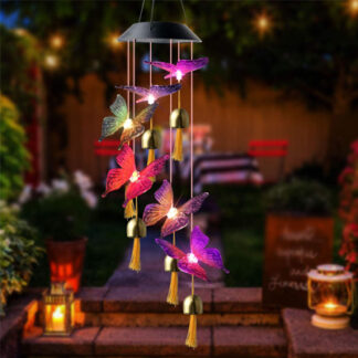 A wind chime to which are attached 6 butterflies is displayed and the butterflies are glowing with 6 different colors, which are solar powered and bells are attached under them.