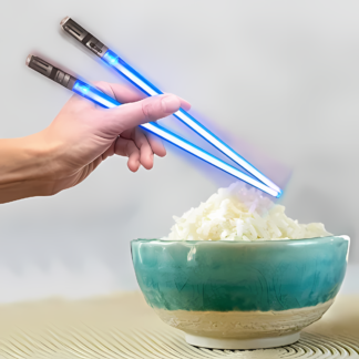 A pair of chopsticks in the form of lightsabers is held by a hand above a bowl of rice.