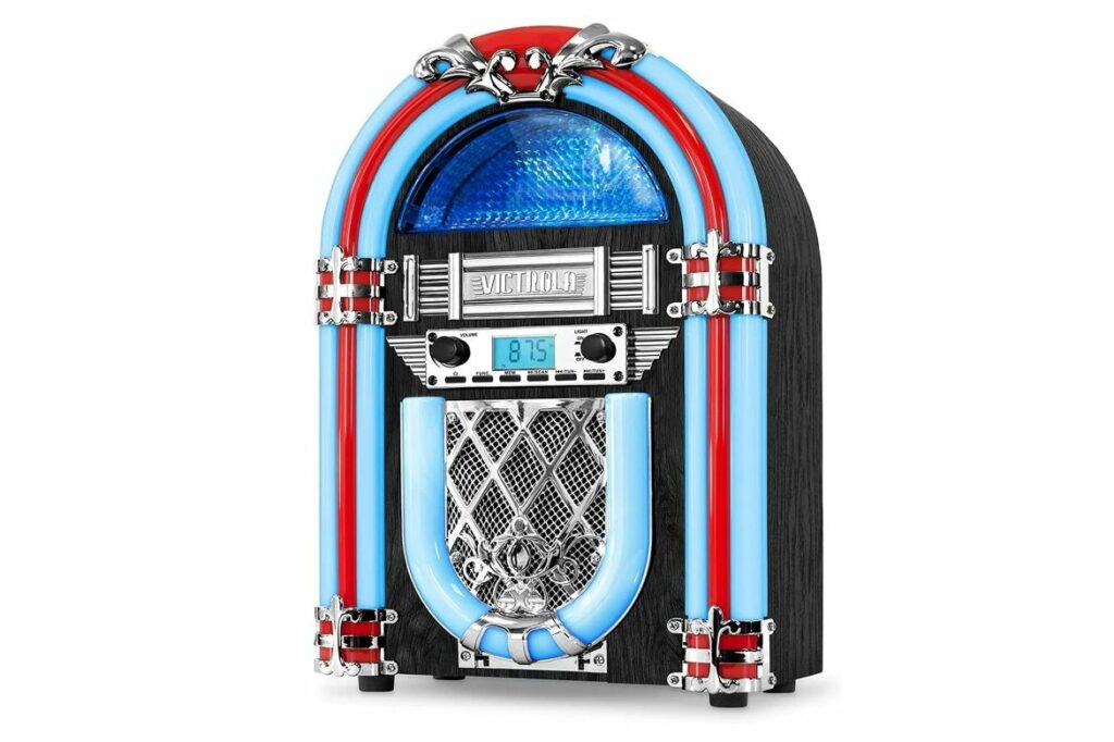 Victrola vintage tabletop jukebox is displayed on its own with its red and blue lights and silver colored metal engravings. It's the best alternative in the vintage tabletop jukebox sale article.