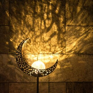A garden stake with a metal crescent with holes holds a lighting sphere inside it and gives an aesthetic look.